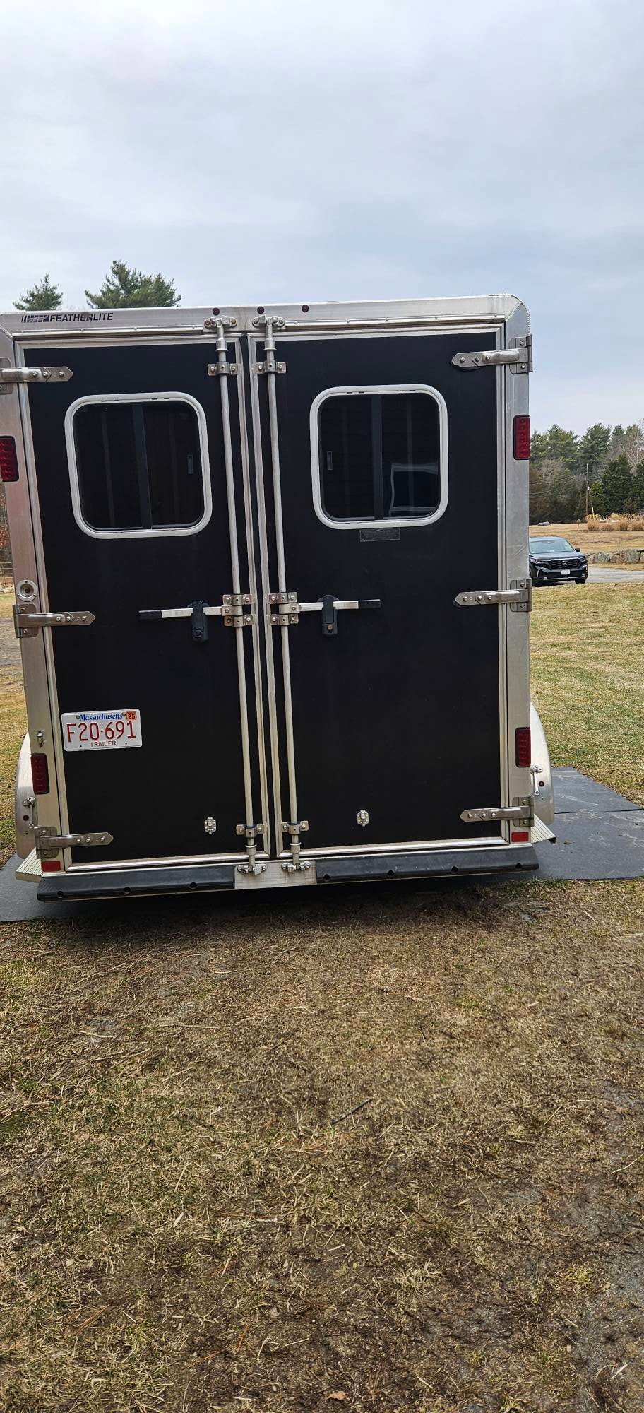 Detailed view of the tandem rubber torsion axles and LED safety lighting on a Featherlite 9409