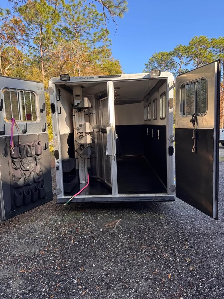 Rear view of the 4-horse slant load with open double doors and rubber floor mats."adjustable saddle rack and multiple bridle hooks