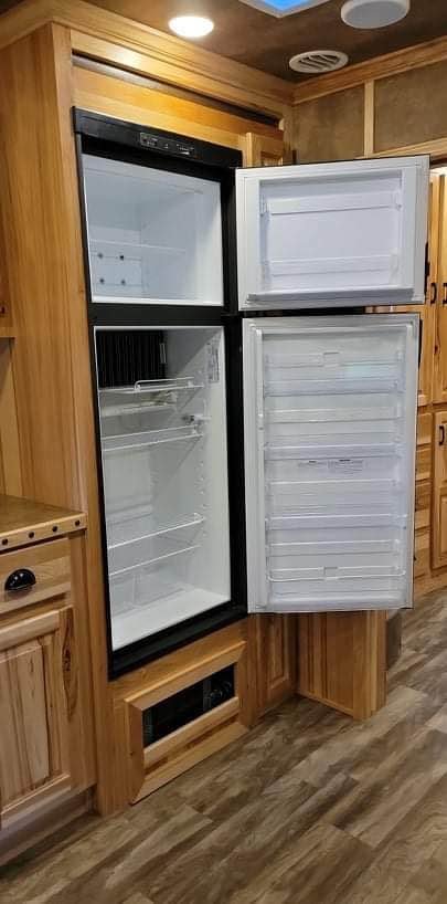 A gourmet kitchen inside the Lakota Bighorn with a large refrigerator and recessed glass cooktop
