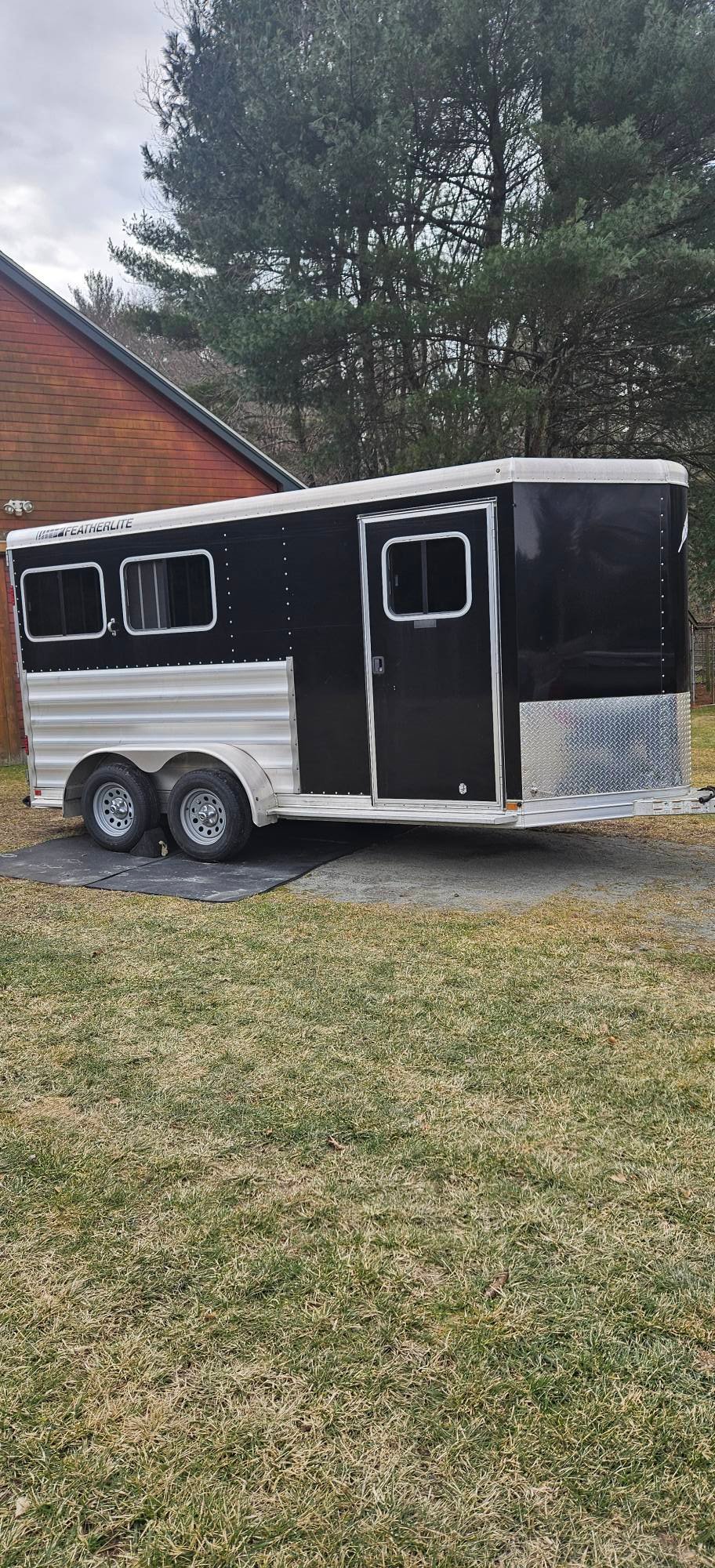 Exterior view of a silver 2020 Featherlite 9409 2-horse bumper pull trailer with a v-nose design